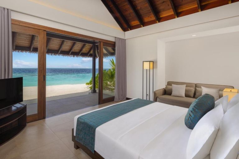 Habitación de lujo con cama doble y vistas al océano turquesa en NOOE Maldives Kunaavashi