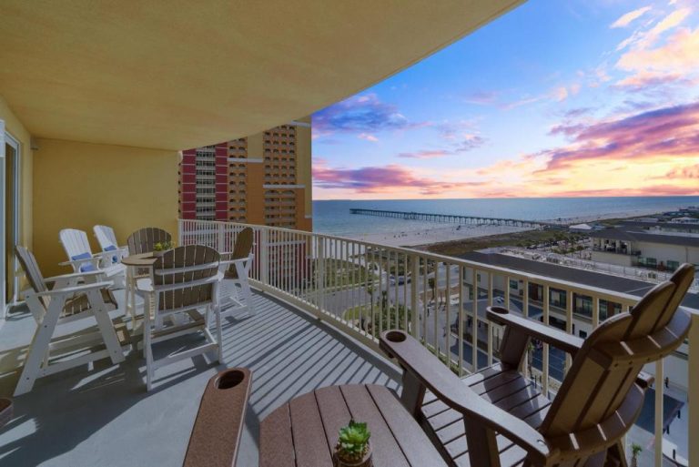 Amplia terraza con sillas Adirondack y vistas al mar y playa en Calypso 3 Luxury Beach al atardecer