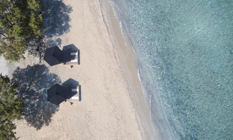 Vista aérea de la playa privada con bungalows frente al mar cristalino del Lango Design Hotel & Spa