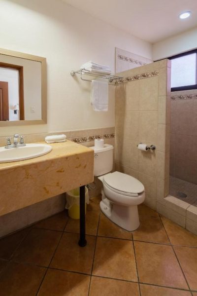 Baño completo con ducha, lavabo de mármol y toilet del Hotel Colli