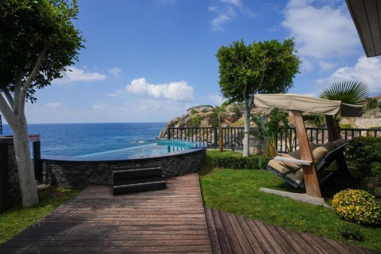 Piscina infinita con vistas al mar y zona de relax en Porto Amore Club Hotel