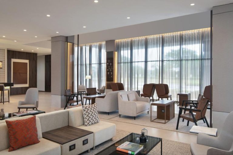 Elegante lobby lounge con sofás y sillones modernos en AC Hotel by Marriott Punta Cana