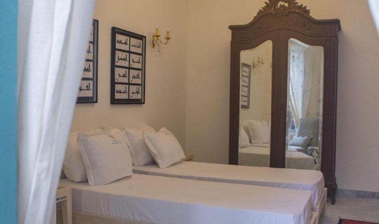 Habitación doble con armario vintage y espejo en Dar Ben Gacem Kahia con decoración árabe