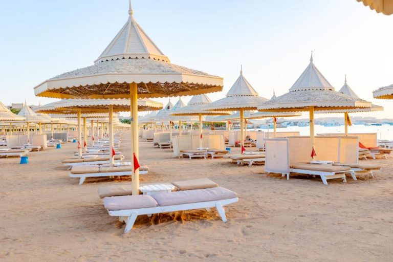Playa privada con tumbonas y sombrillas elegantes de The Grand Hotel Hurghada en Egipto