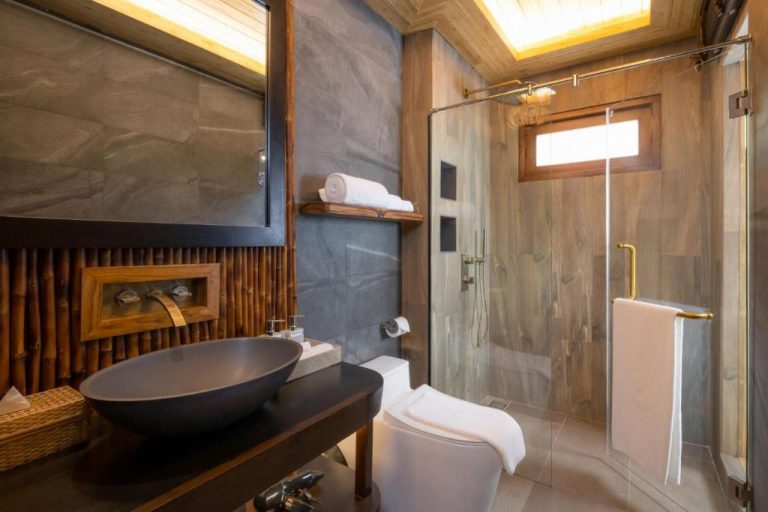 Baño de lujo con ducha de cristal y detalles de bambú en SINAE Phuket Luxury Hotel