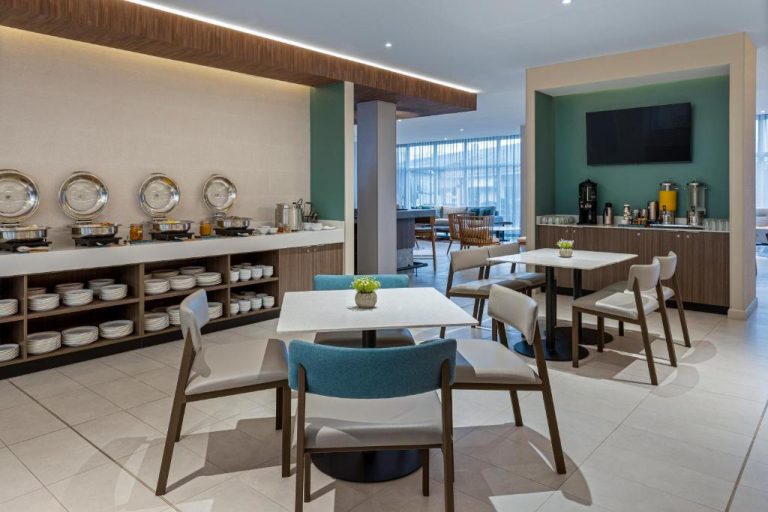 Área de desayuno buffet con mesas y zona de servicio en Fairfield by Marriott San Jose Airport Alajuela