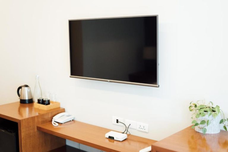 Habitación con televisión de pantalla plana y escritorio de madera en Solitude Acacia Resort