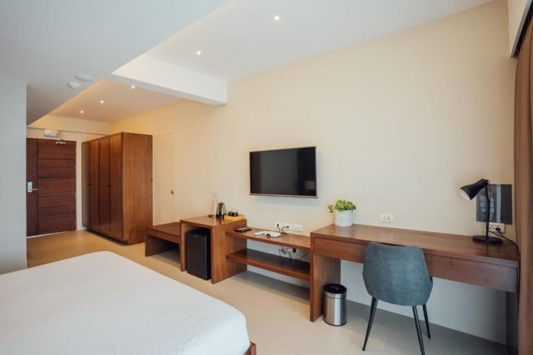 Habitación moderna con escritorio de madera y televisión del Solitude Acacia Resort
