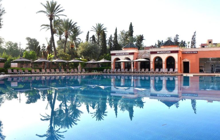 Piscina exterior con tumbonas y restaurante marroquí del Royal Mirage Deluxe en Marrakech