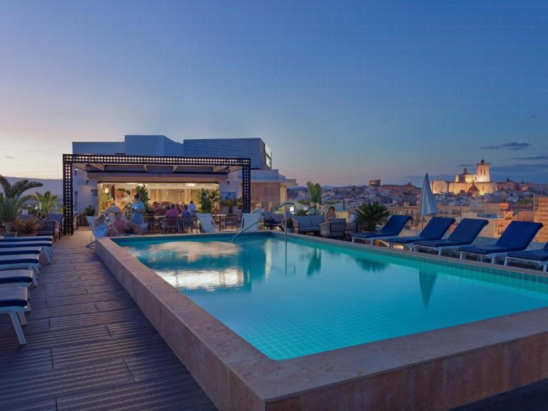 Piscina en la azotea del H10 Imperial Tarraco con vistas a la ciudad de Tarragona al atardecer
