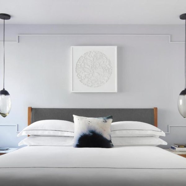 Habitación elegante con cama king size y lámparas colgantes en Kimpton Virgilio Polanco by IHG