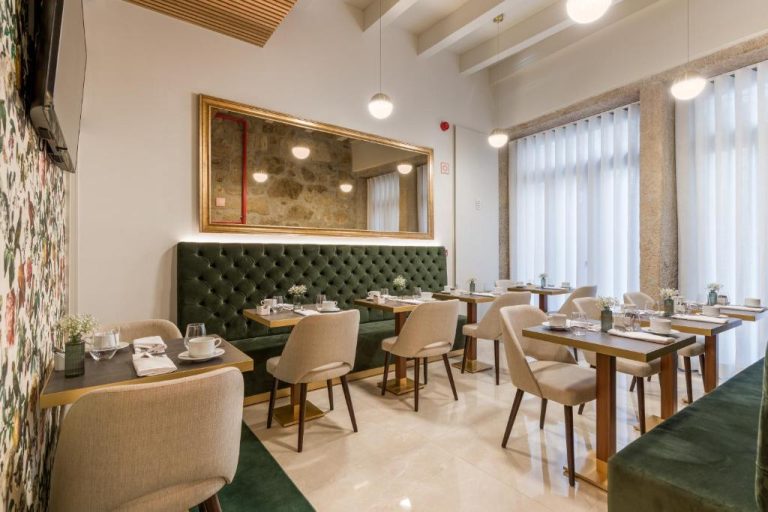 Salón restaurante con sofás de terciopelo verde y mesas elegantes del Ribeira Douro Hotel