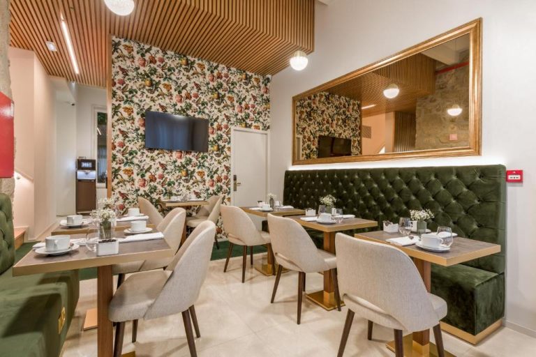 Salón de desayunos elegante con tapizado verde y papel pintado floral del Ribeira Douro Hotel