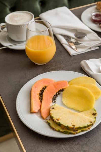 Desayuno con frutas tropicales, zumo de naranja y café con leche en el Ribeira Douro Hotel