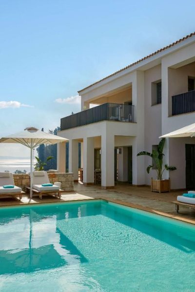 Piscina exterior con tumbonas y sombrillas del Angsana Corfu Resort & Spa con vistas al mar