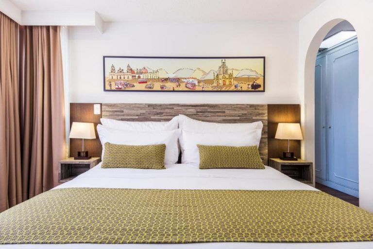 Habitación doble con cama king size y decoración colonial en Hotel Vilar América