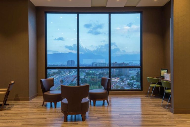 Sala de estar con sillones y vista panorámica a la ciudad en Hampton by Hilton Bogotá Airport