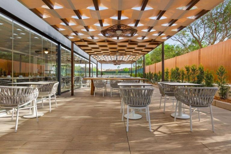 Terraza exterior con pérgola y mesas del Wyndham Residences Alvor Beach en Portugal