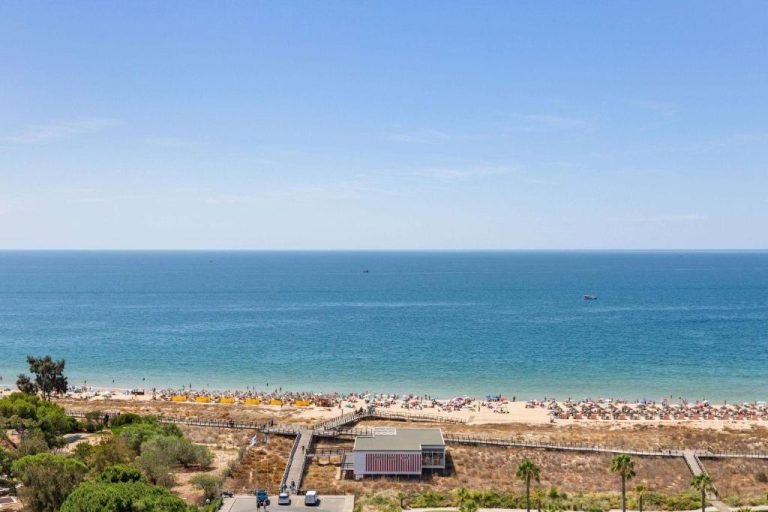 Vista aérea de la playa de Alvor con tumbonas y acceso directo desde Wyndham Residences Alvor Beach