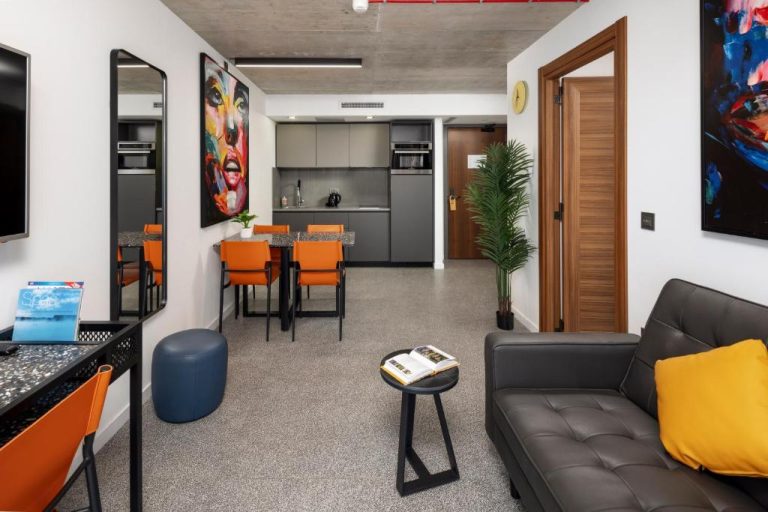 Salón con sofá de cuero y cocina integrada en apartamento del Grands Suites Hotel and Spa Sliema