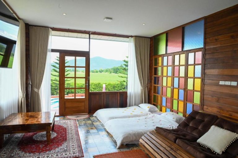 Habitación con dos camas y pared colorida con vistas al campo y montaña en DooNa Resort
