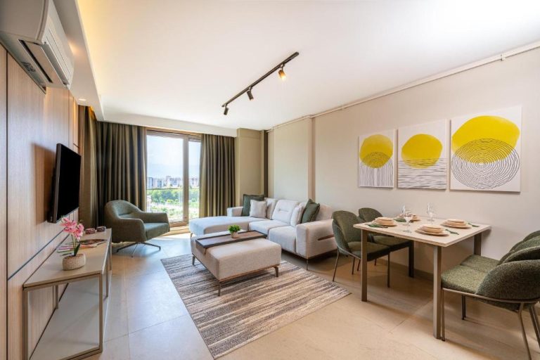 Salón comedor moderno con sofá, mesa de comedor y arte decorativo en Casamax Suites