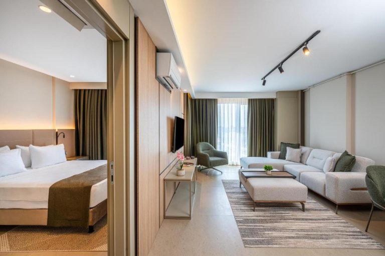 Suite con salón moderno y dormitorio separado en Casamax Suites, decoración elegante en tonos neutros