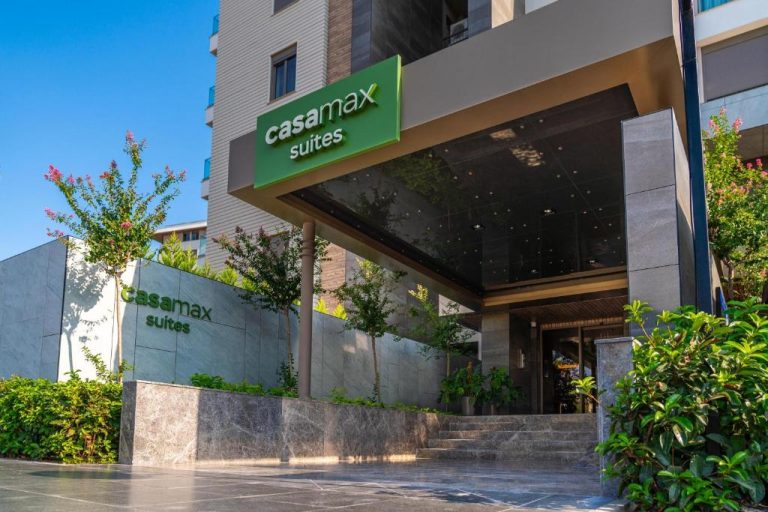 Fachada y entrada principal del hotel Casamax Suites con jardines y marquesina moderna