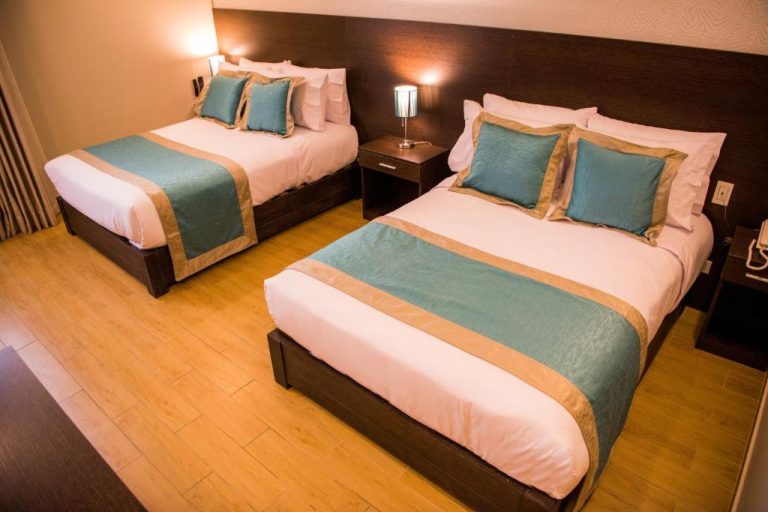 Habitación doble con dos camas y decoración en tonos azules y dorados en Hotel Diamond Lima