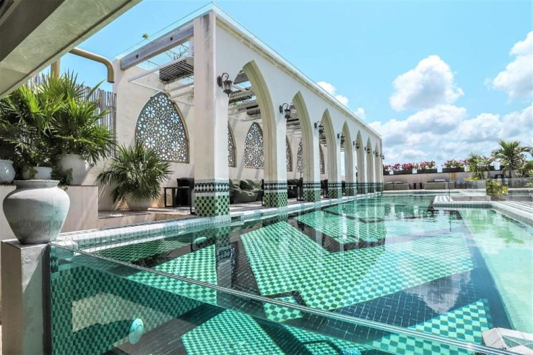 Piscina infinity con mosaicos verdes y arcos de estilo morisco en el hotel Layla Tulum Adults Only