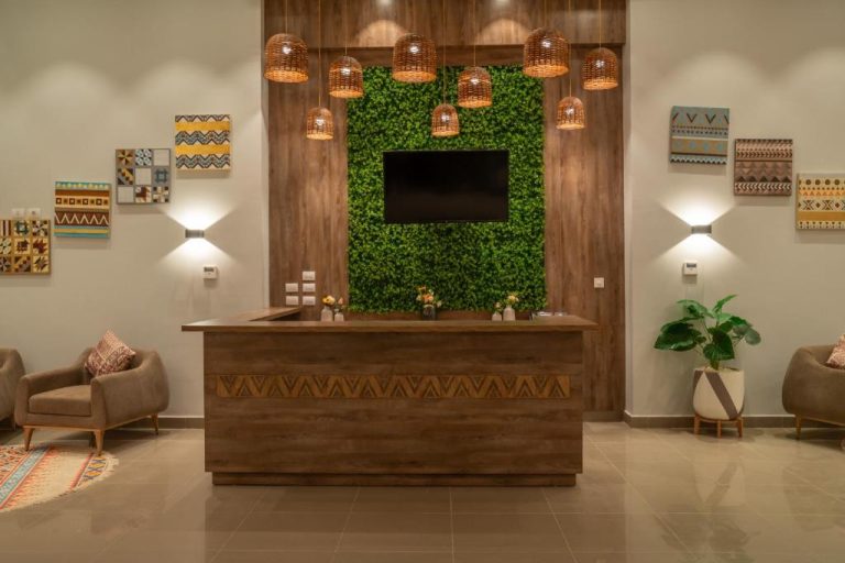 Recepción moderna con pared verde y lámparas de mimbre del Azal Lagoons Resort Abu Simbel