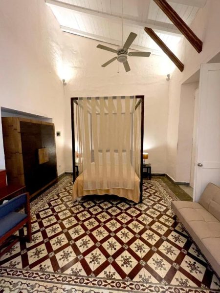 Habitación con cama de dosel y suelo hidráulico artesanal en Hotel Boutique Casa Sánchez