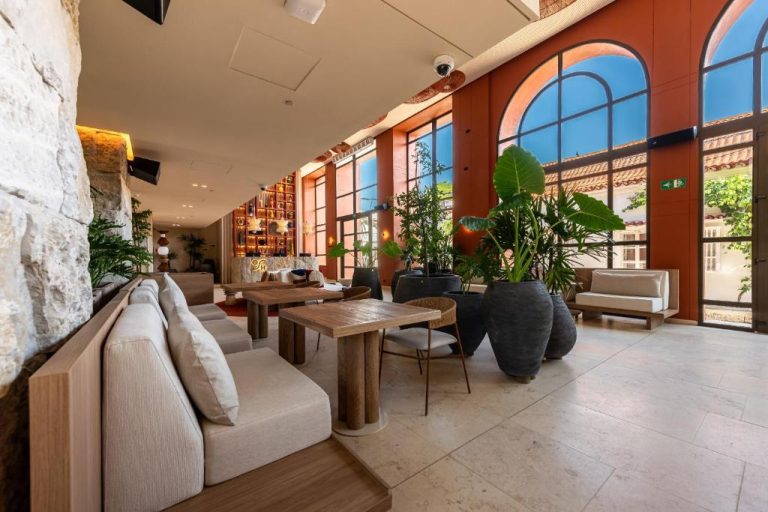 Elegante lobby con sofás, mesas de madera y plantas tropicales en Osh Hotel Cartagena