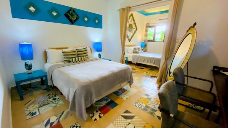 Habitación doble con decoración azul y suelo hidráulico en Hotel Boutique Casa Sánchez