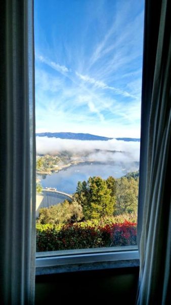 Vista panorámica del embalse con niebla y presa desde ventana del Hotel Da Montanha