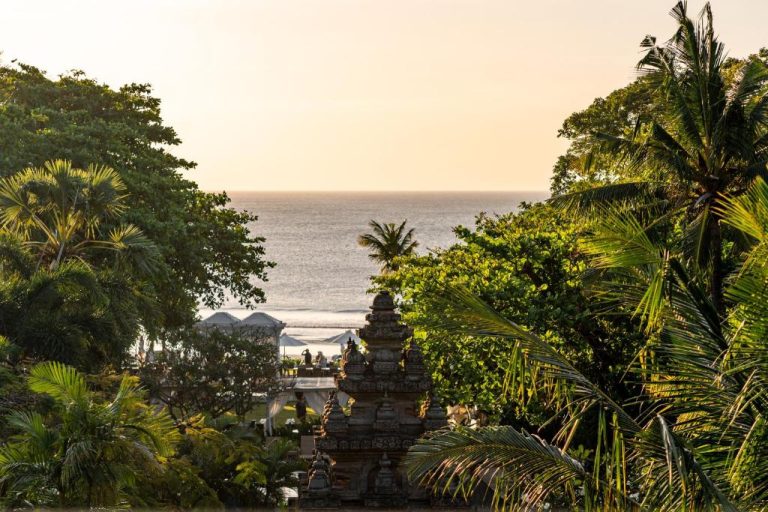Vista del océano desde el Bali Garden Beach Resort con templo balinés tradicional rodeado de palmeras tropicales