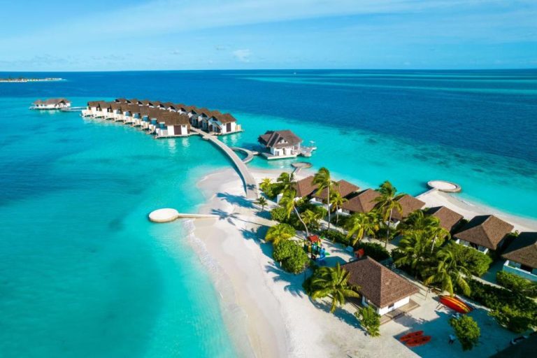Vista aérea de las villas sobre el agua del NOOE Maldives Kunaavashi con laguna turquesa y playa blanca