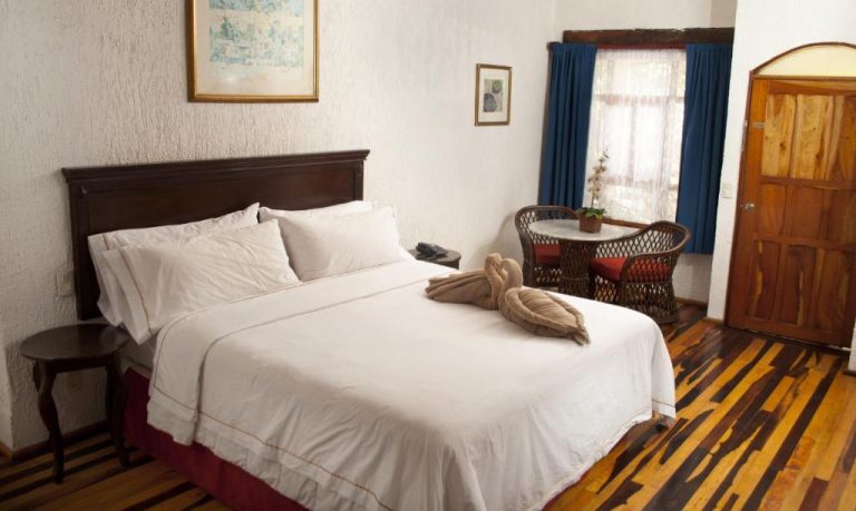 Habitación doble con cama matrimonial y suelo de madera en Eco-hotel El Rey del Caribe