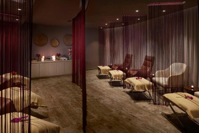 Sala de relajación del spa en Azul Beach Resort Negril con tumbonas y cortinas decorativas