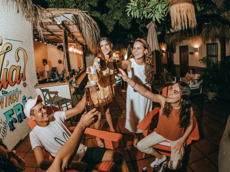 Grupo de jóvenes brindando con cervezas en la terraza social del Viajero Cartagena Centro Hostel