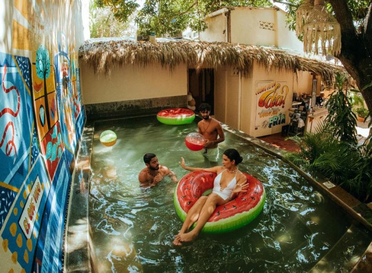 Huéspedes disfrutando de la piscina con flotadores de sandía en Viajero Cartagena Centro Hostel