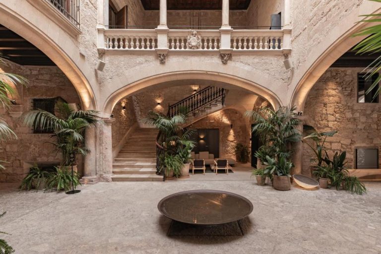 Patio interior con arcos de piedra, escalera y jardines del Nobis Hotel Palma, Design Hotels