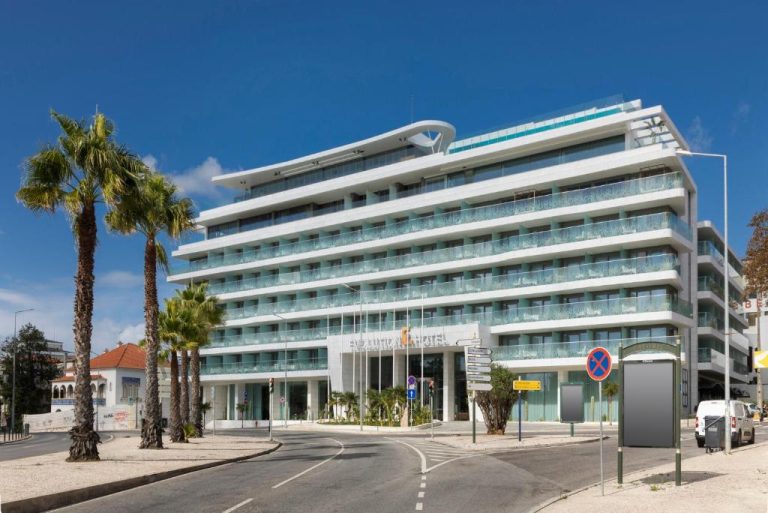 Fachada exterior moderna del Evolution Cascais-Estoril Hotel con palmeras y balcones acristalados