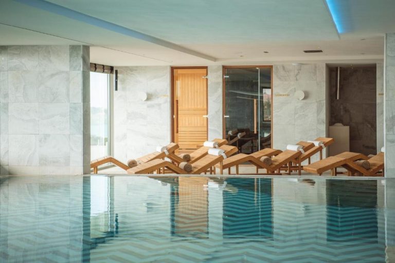 Piscina interior con tumbonas y zona de sauna del EVOLUTION Cascais-Estoril Hotel