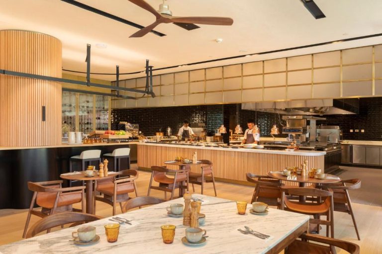 Restaurante con cocina abierta y mesas de mármol en el EVOLUTION Cascais-Estoril Hotel