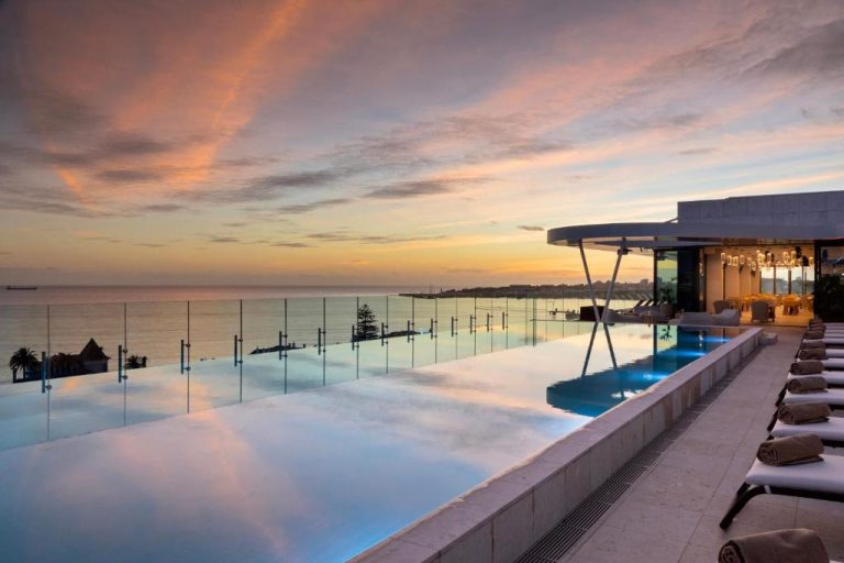 Piscina infinita con vistas al mar al atardecer en el EVOLUTION Cascais-Estoril Hotel