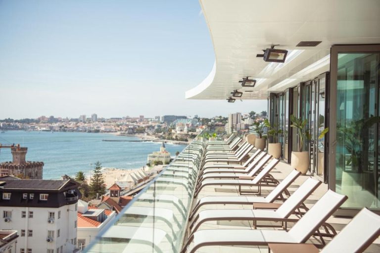 Terraza solarium con tumbonas y vistas al mar del Evolution Cascais-Estoril Hotel en Portugal