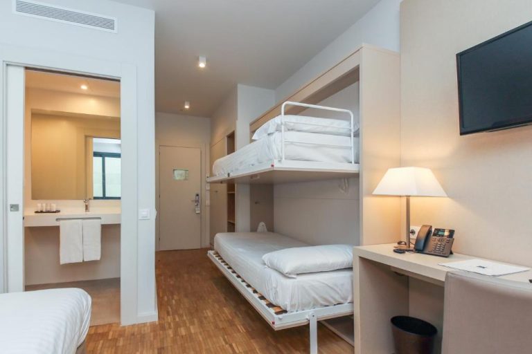 Habitación familiar con camas literas y escritorio en Hotel Lauria, ideal para familias