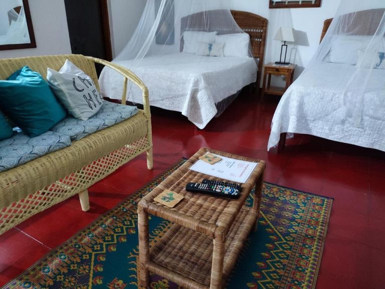 Habitación doble con dos camas, mobiliario de ratán y mosquiteras en el hotel Ltu Garden