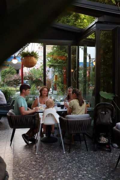 Familia disfrutando de una comida en la terraza acristalada del restaurante del Comfort Suites
